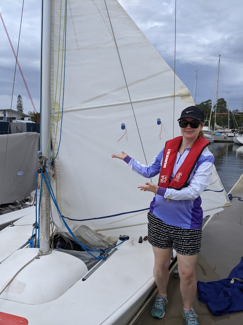 My wife standing next to an Elliot 6 at dock with a half-raised mainsail. My wife standing next to an Elliot 6 at dock with a half-raised mainsail.