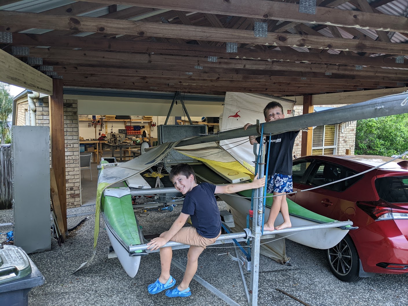 A photo of the boat under our carport with two boys climbing on it. A photo of the boat under our carport with two boys climbing on it.