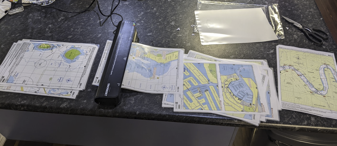 A photo of a pile of A4 printed charts being laminated on my kitchen bench. A photo of a pile of A4 printed charts being laminated on my kitchen bench.