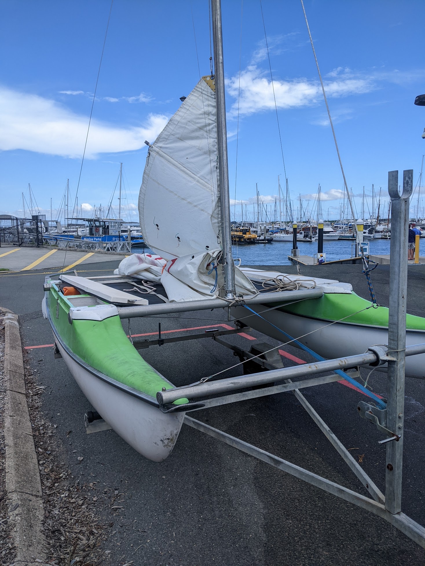 A photo of our boat on the trailer with only the mainsail half-raised.