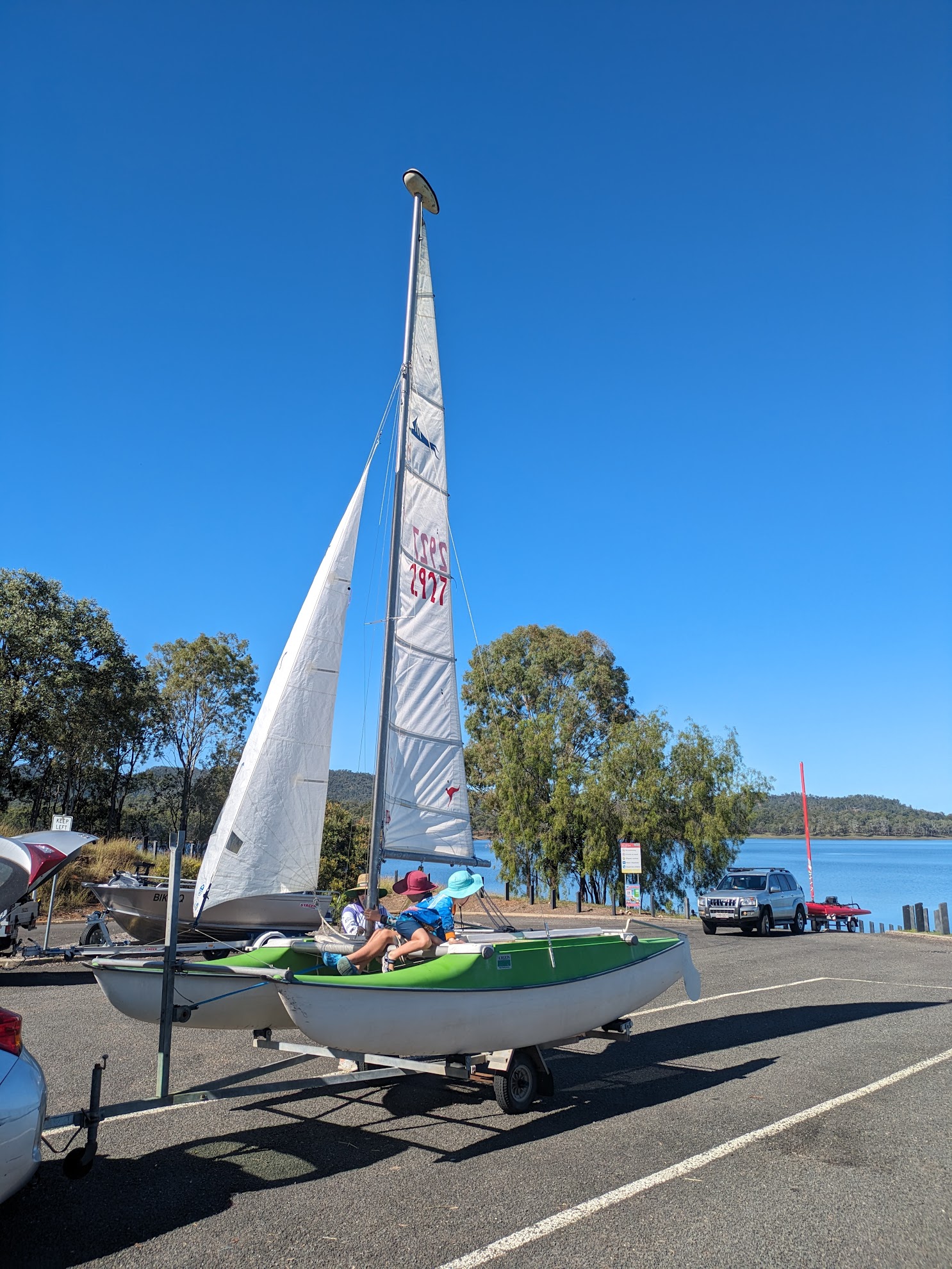 A photo of the boat on the trailer with the sails up.