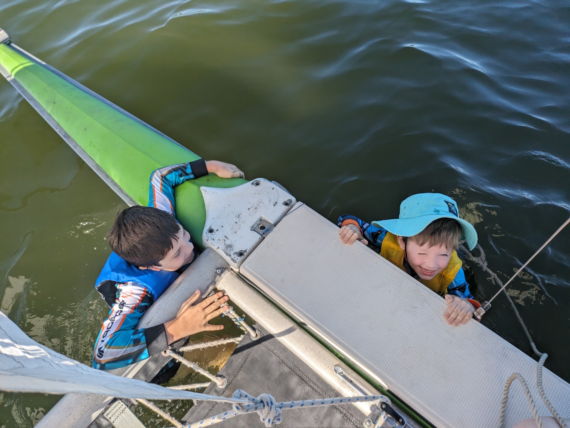 A photo of both the kids holding onto the front of the boat.