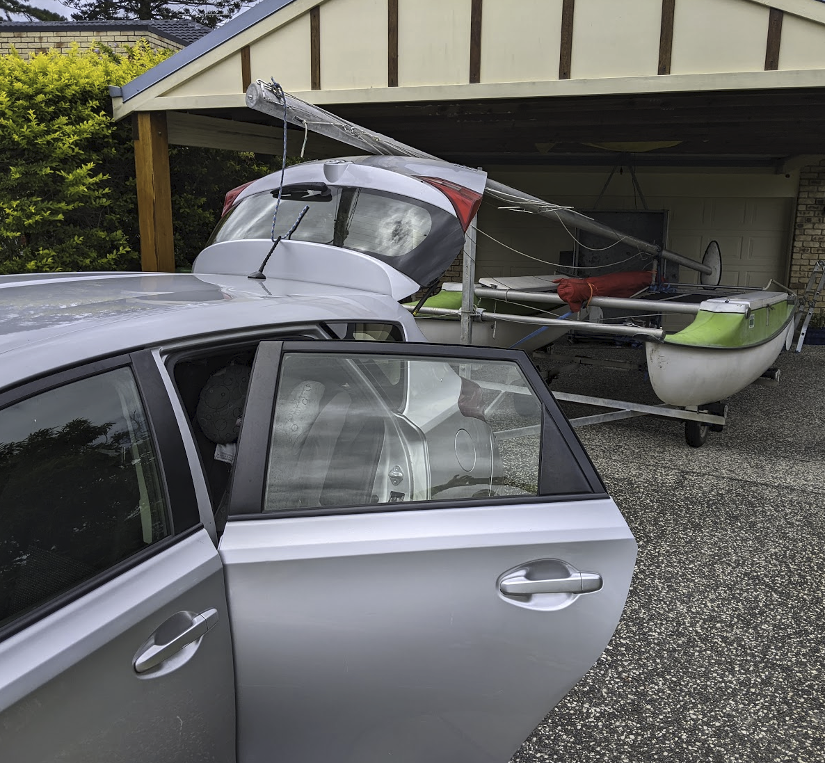 A photo of the boat on its trailer behind our silver corolla.