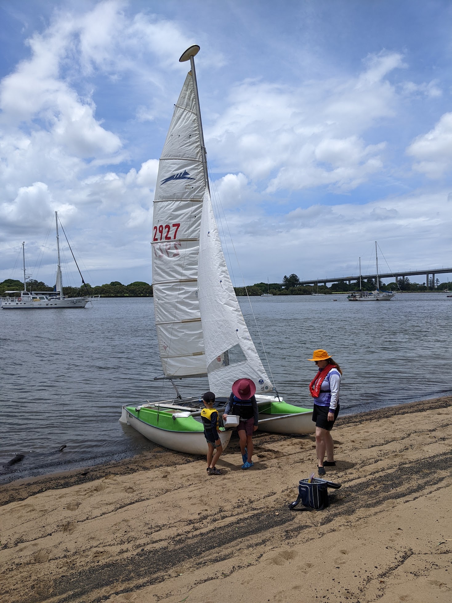 A photo of our boat pulled up on the sand. Alex, Sam and Michelle are standing on the beach in front of it.